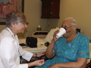 doctor assistant patient as she takes drink